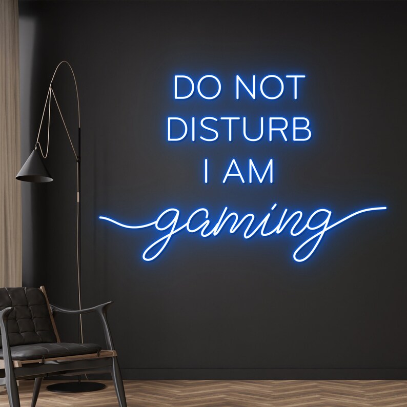 "Do Not Disturb I Am Gaming" LED Neon sign by LEDNeons -  lit up on a wall, adding bold style to a gamer’s room.