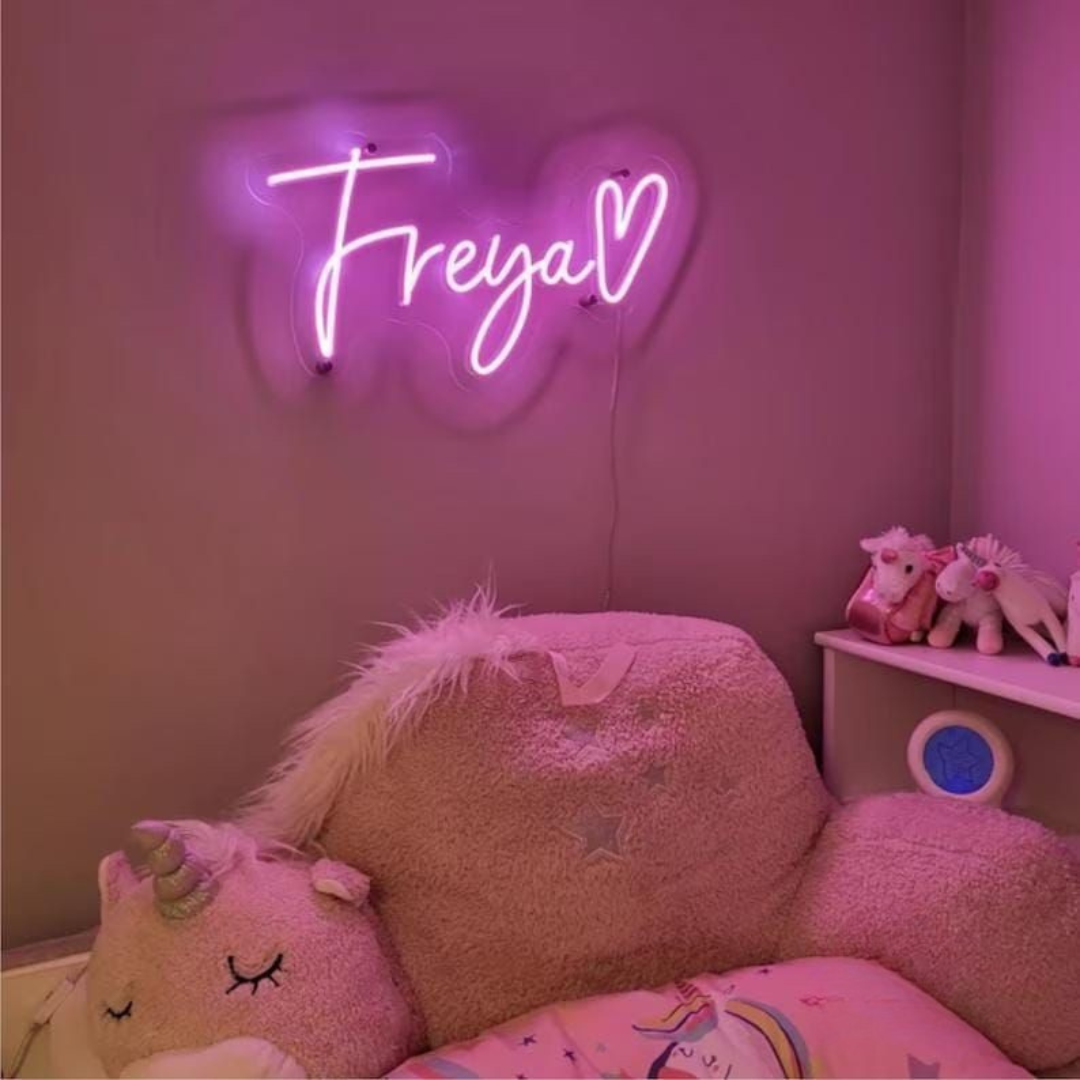 "Freya Name LED Neon Sign by LEDNeons -  glowing in stylish cursive font on a wall backdrop"