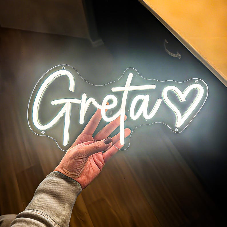 Greta Name LED Neon sign by LedNeons.com -  glowing on a wall, adding a personalized and stylish decorative element.