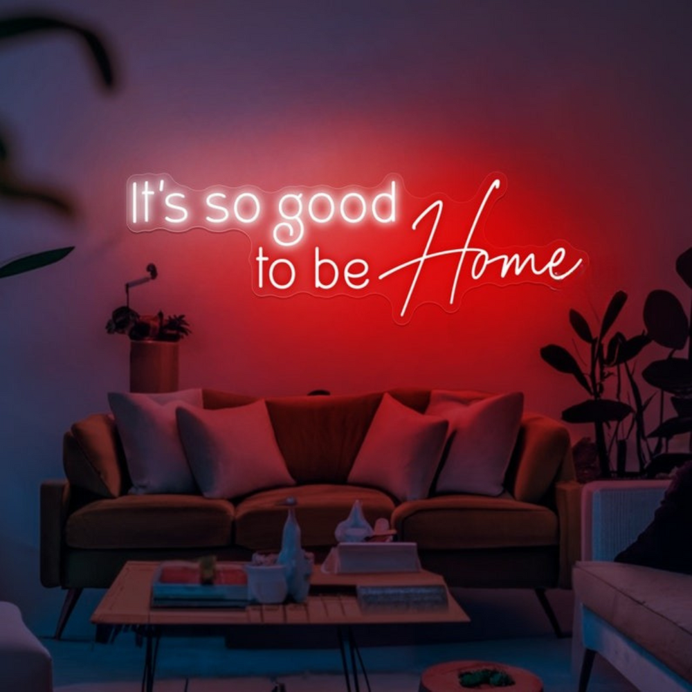 It's So Good To Be Home Neon Sign by LEDNeons  - Glowing in warm light, mounted on a wall in a cozy home setting.
