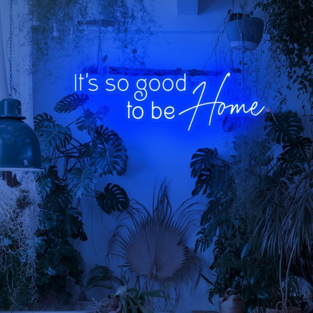 It's So Good To Be Home Neon Sign by LEDNeons  - Glowing in warm light, mounted on a wall in a cozy home setting.