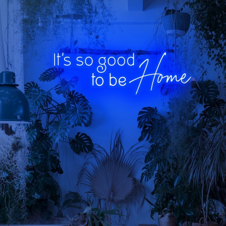 It's So Good To Be Home Neon Sign by LEDNeons  - Glowing in warm light, mounted on a wall in a cozy home setting.