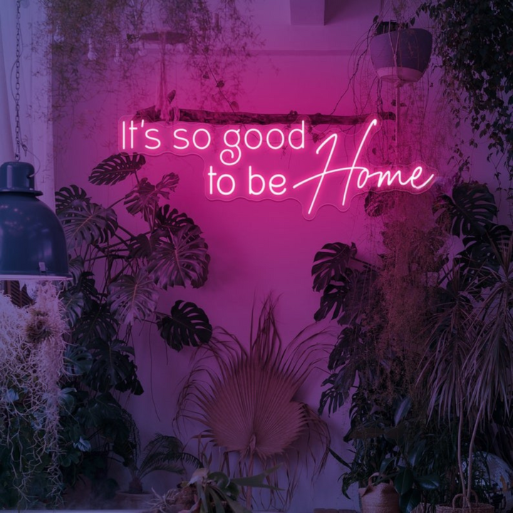 It's So Good To Be Home Neon Sign by LEDNeons  - Glowing in warm light, mounted on a wall in a cozy home setting.