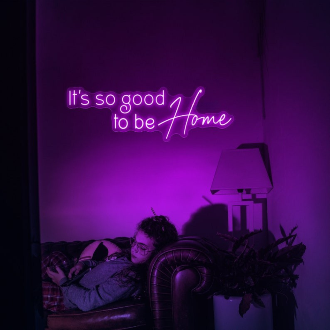It's So Good To Be Home Neon Sign by LEDNeons  - Glowing in warm light, mounted on a wall in a cozy home setting.
