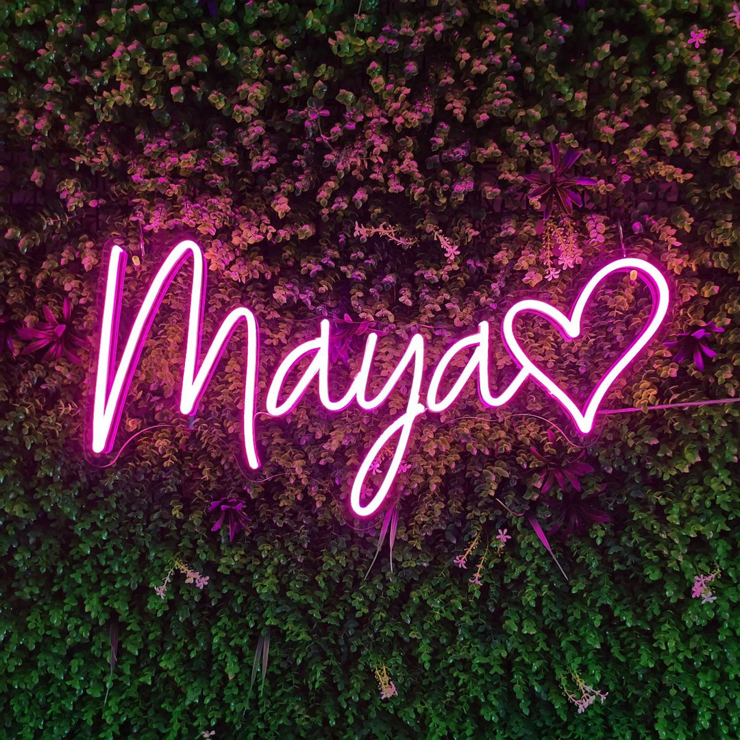 "Maya Name LED Neon Sign by LedNeons.com -  glowing in elegant cursive font on a wall backdrop"