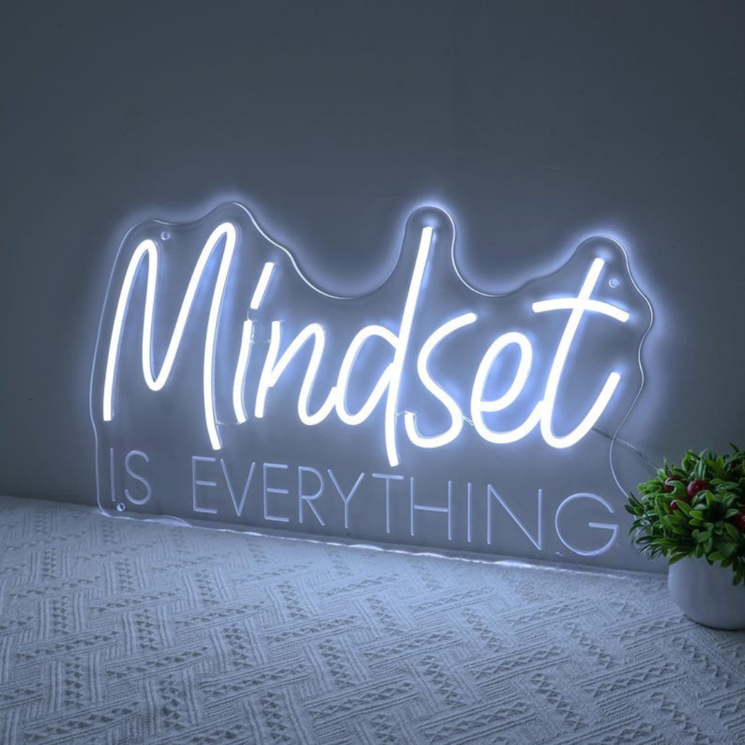 Mindset is Everything" LED Neon sign by LEDNeons - Glowing brightly on a wall, creating a motivational atmosphere in a home office or personal workout space.