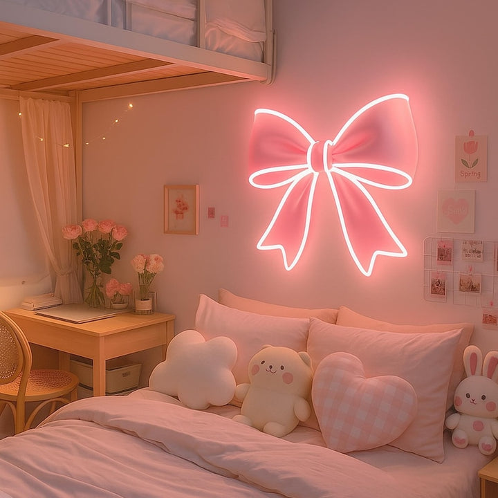Pink bow-shaped LED Neon sign by LedNeons.com - glowing softly on a wall, adding a cute and feminine touch to the decor.
