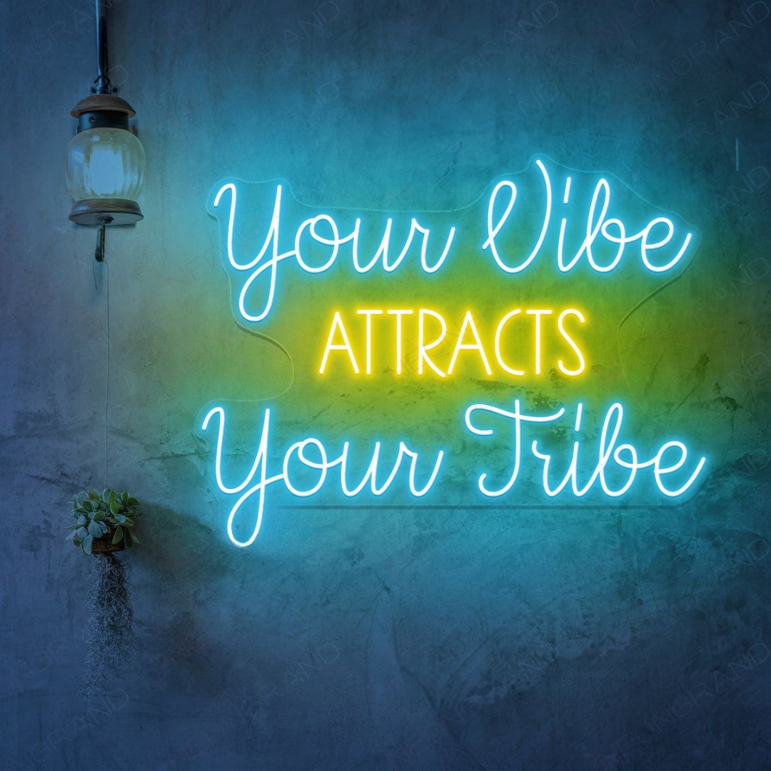 Your Vibe Attracts Your Tribe" LED Neon sign by LEDNeons  glowing brightly on a wall, creating a positive and welcoming atmosphere.