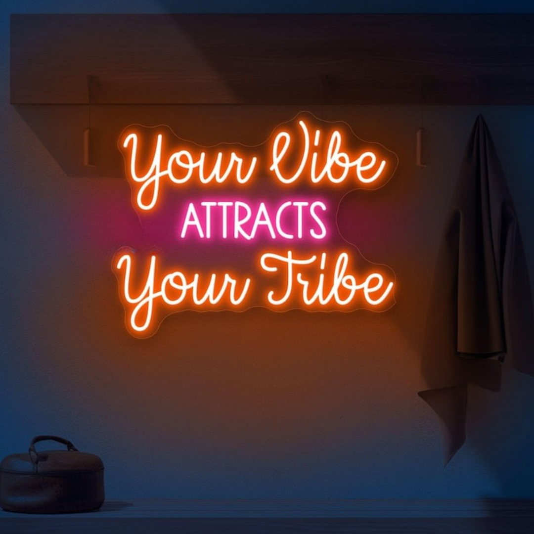 "Your Vibe Attracts Your Tribe" LED Neon sign by LEDNeon's  glowing brightly on a wall, creating a positive and welcoming atmosphere.